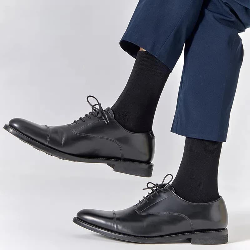 Black dress socks worn with black leather shoes and navy trousers
