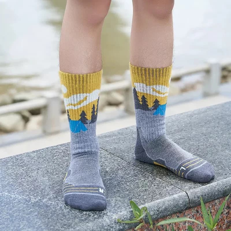 Gray crew socks with yellow cuffs and mountain-inspired patterns